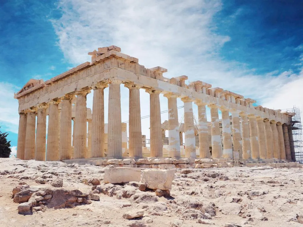 Der Parthenon mit hellen Steinsäulen steht vor einem lebhaften blauen Himmel